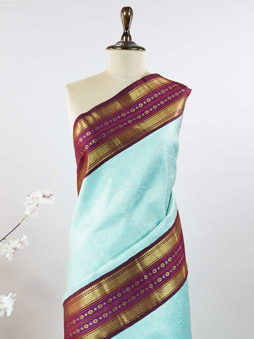 Kanchipuram Silk This elegant Kanjivaram saree features an aqua blue body with a rich maroon border, crafted from 100% pure silk. Handloom woven with full brocade and intricate meena work on the border and pallu, it reflects the timeless artistry of Kanchipuram. Chintamani - Aqua Blue Pure Kanjivaram Silk Saree - Manoranjitham Weaves - Handloom Store