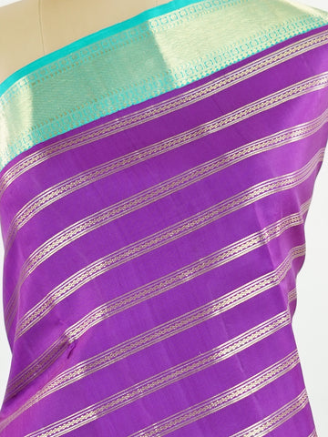 Kanchipuram Silk This Kanjivaram silk saree, adorned in Violet and detailed with Pure Zari weaving, reflects the grandeur of Kanchipuram. The timeless Buttis motifs enhance its bridal charm. A perfect blend of luxury and tradition, it is designed for those who appreciate fine craftsmanship. Sarasangi - Manoranjitham Weaves - Handloom Store