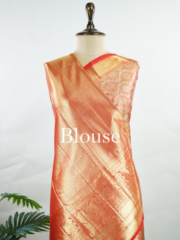 Kanchipuram Silk This Kanjivaram silk saree, adorned in Coral  and detailed with Pure Zari weaving, reflects the grandeur of Kanchipuram. The timeless Buttis motifs enhance its bridal charm. A perfect blend of luxury and tradition, it is designed for those who appreciate fine craftsmanship. Kalyani - Manoranjitham Weaves - Handloom Store