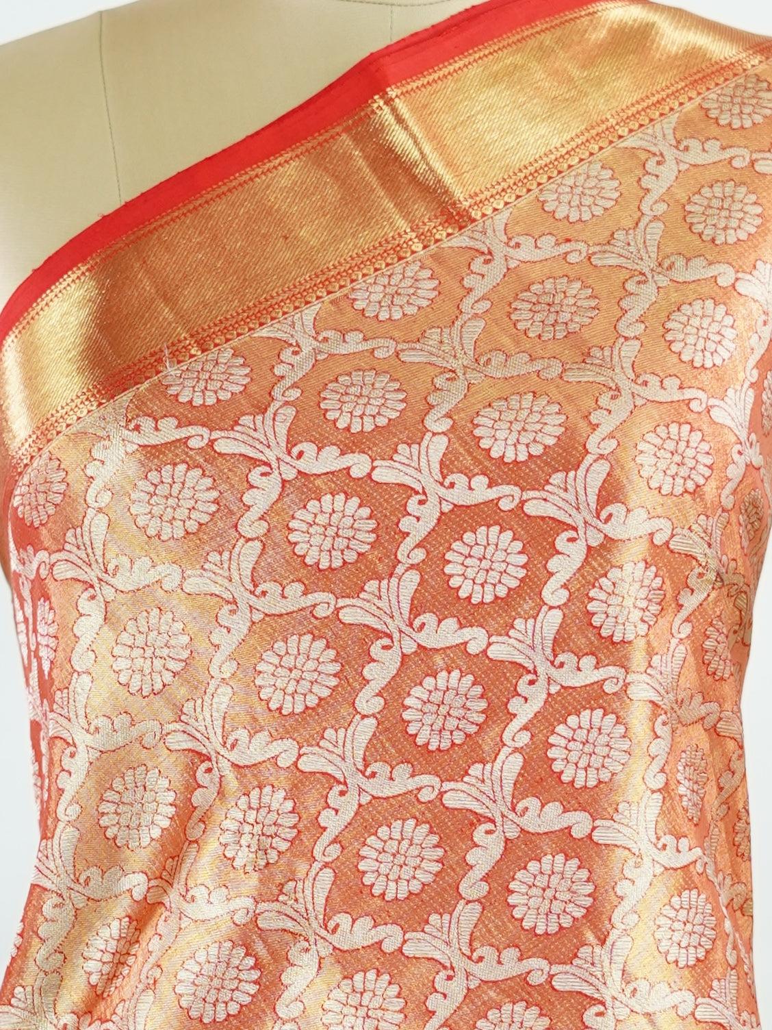 Kanchipuram Silk This Kanjivaram silk saree, adorned in Coral  and detailed with Pure Zari weaving, reflects the grandeur of Kanchipuram. The timeless Buttis motifs enhance its bridal charm. A perfect blend of luxury and tradition, it is designed for those who appreciate fine craftsmanship. Kalyani - Manoranjitham Weaves - Handloom Store