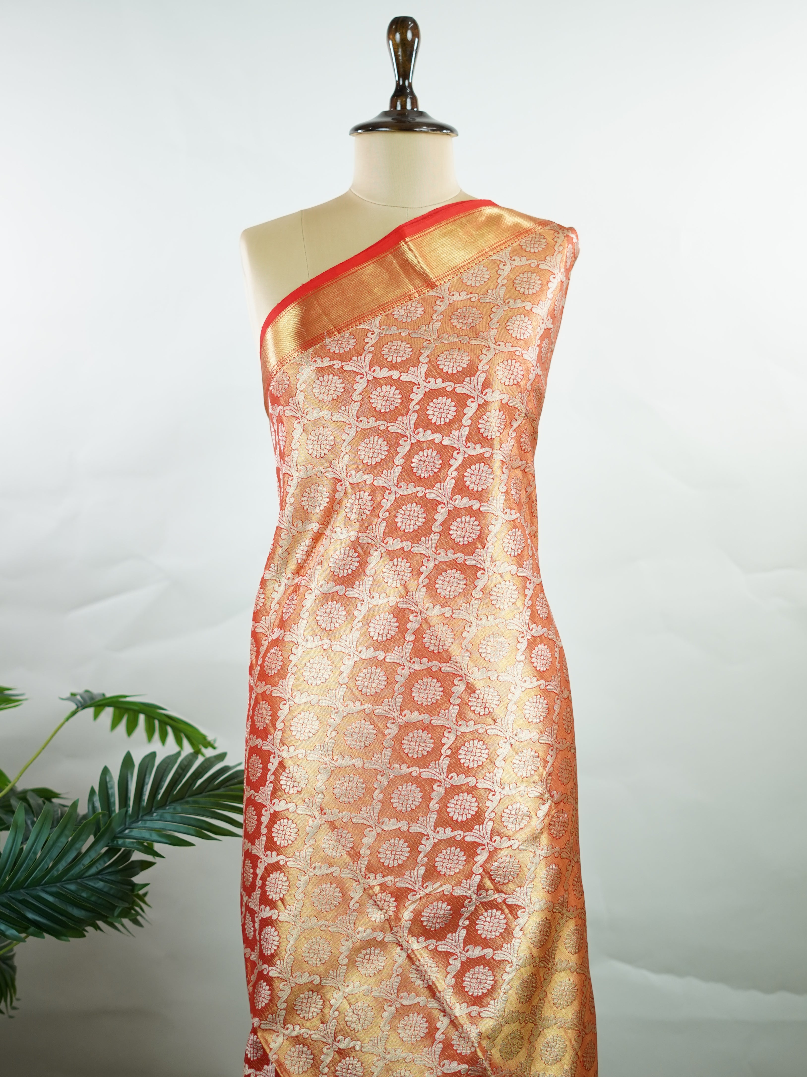 Kanchipuram Silk This Kanjivaram silk saree, adorned in Coral  and detailed with Pure Zari weaving, reflects the grandeur of Kanchipuram. The timeless Buttis motifs enhance its bridal charm. A perfect blend of luxury and tradition, it is designed for those who appreciate fine craftsmanship. Kalyani - Manoranjitham Weaves - Handloom Store