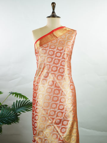 Kanchipuram Silk This Kanjivaram silk saree, adorned in Coral  and detailed with Pure Zari weaving, reflects the grandeur of Kanchipuram. The timeless Buttis motifs enhance its bridal charm. A perfect blend of luxury and tradition, it is designed for those who appreciate fine craftsmanship. Kalyani - Manoranjitham Weaves - Handloom Store