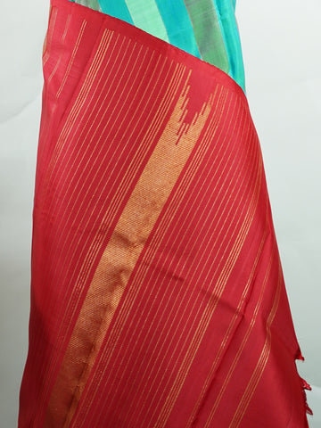 Kanchipuram Silk A masterpiece from Kanchipuram, this Kanjivaram saree in Green Brown  is a tribute to India's rich handloom legacy. The Pure Zari weaving and Buttis  motifs make it a perfect choice for brides and celebrations. Every thread speaks of elegance, tradition, and the skilled hands that bring this saree to life. Kambhoji - Manoranjitham Weaves - Handloom Store