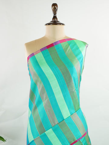 Kanchipuram Silk A masterpiece from Kanchipuram, this Kanjivaram saree in Green Brown  is a tribute to India's rich handloom legacy. The Pure Zari weaving and Buttis  motifs make it a perfect choice for brides and celebrations. Every thread speaks of elegance, tradition, and the skilled hands that bring this saree to life. Kambhoji - Manoranjitham Weaves - Handloom Store