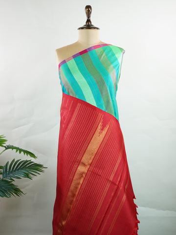 Kanchipuram Silk A masterpiece from Kanchipuram, this Kanjivaram saree in Green Brown  is a tribute to India's rich handloom legacy. The Pure Zari weaving and Buttis  motifs make it a perfect choice for brides and celebrations. Every thread speaks of elegance, tradition, and the skilled hands that bring this saree to life. Kambhoji - Manoranjitham Weaves - Handloom Store