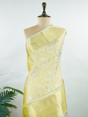 Kanchipuram Silk This 100% Pure Silk  silk saree, adorned in Butter yellow and detailed with Pure Zari weaving, reflects the grandeur of Maharashtra. The timeless Buttis motifs enhance its bridal charm. A perfect blend of luxury and tradition, it is designed for those who appreciate fine craftsmanship. Tilak - Pure Kanjivaram Silk Saree | Pure Zari - Manoranjitham Weaves - Handloom Store