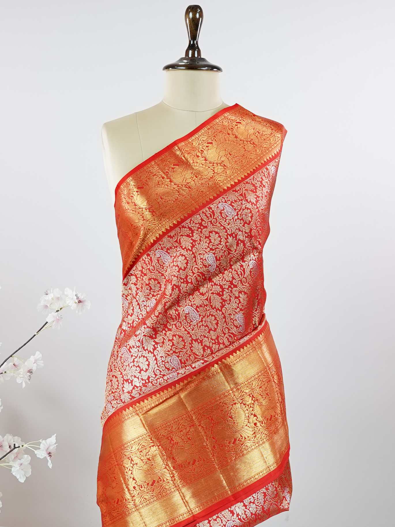 Kanchipuram Silk This 100% Pure Silk  silk saree, adorned in Red and detailed with Pure Zari weaving, reflects the grandeur of Maharashtra. The timeless Buttis motifs enhance its bridal charm. A perfect blend of luxury and tradition, it is designed for those who appreciate fine craftsmanship. Hemanta - Red Pure Kanjivaram Silk Saree | Pure Zari - Manoranjitham Weaves - Handloom Store