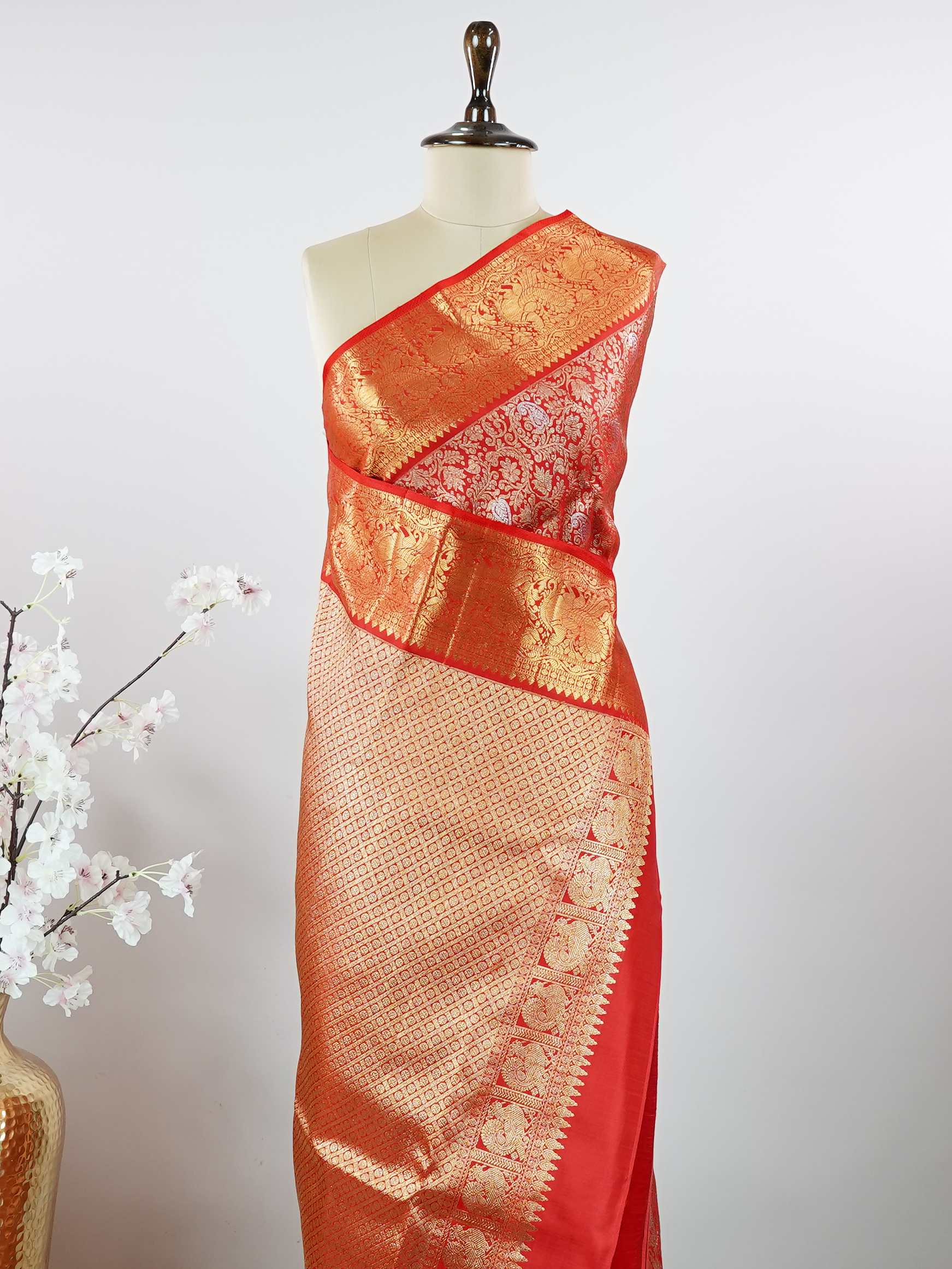 Kanchipuram Silk This 100% Pure Silk  silk saree, adorned in Red and detailed with Pure Zari weaving, reflects the grandeur of Maharashtra. The timeless Buttis motifs enhance its bridal charm. A perfect blend of luxury and tradition, it is designed for those who appreciate fine craftsmanship. Hemanta - Red Pure Kanjivaram Silk Saree | Pure Zari - Manoranjitham Weaves - Handloom Store