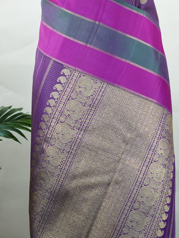 Kanchipuram Silk Experience the elegance of this pure Zari Oosi Kattam saree from Kanchipuram, featuring intricate gold and silver threads woven into a rich purple fabric. The vibrant multi-gap borders in pink and green add a striking contrast, perfect for festive occasions. This masterpiece combines comfort and artistry, making it a timeless choice for celebrations. Padma - Manoranjitham Weaves - Handloom Store
