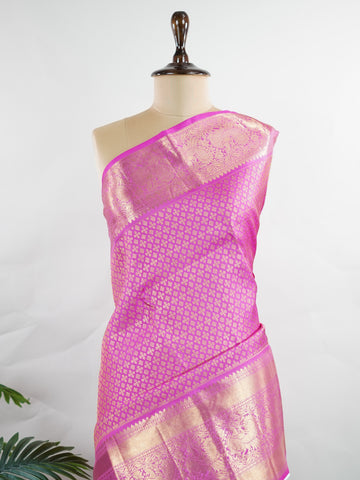 Kanchipuram Silk Beautiful vintage Kanjivaram saree featuring a charming Pink body, perfectly complemented by a matching Pink border and elegant Pink pallu. The monochromatic pink palette exudes grace, femininity, and timeless traditional beauty. Expertly woven with heritage craftsmanship, the saree reflects vintage elegance with a soft and sophisticated appeal. Paired with a plain Pink blouse, this exquisite drape is ideal for weddings, festive celebrations, and special occasions. Vareshni - Pure Kanjivara