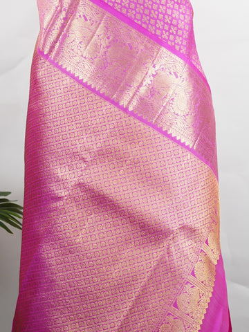 Kanchipuram Silk Beautiful vintage Kanjivaram saree featuring a charming Pink body, perfectly complemented by a matching Pink border and elegant Pink pallu. The monochromatic pink palette exudes grace, femininity, and timeless traditional beauty. Expertly woven with heritage craftsmanship, the saree reflects vintage elegance with a soft and sophisticated appeal. Paired with a plain Pink blouse, this exquisite drape is ideal for weddings, festive celebrations, and special occasions. Vareshni - Pure Kanjivara