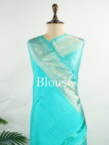 Kanchipuram Silk A pure Kanchipuram silk in tranquil cyan, adorned with gold and silver zari buttas. The self-border enhances the saree's seamless elegance, making it an exquisite choice for celebrations. Woven with precision, this handloom drape is a timeless ode to tradition.    #ManoranjithamSilks #KanjivaramHandloom #PureSilkSaree #BridalElegance #TimelessTradition Charukesi - Pure Kanjivaram Silk Saree | Zari Buttas - Manoranjitham Weaves - Handloom Store