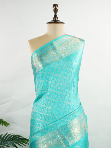 Kanchipuram Silk A pure Kanchipuram silk in tranquil cyan, adorned with gold and silver zari buttas. The self-border enhances the saree's seamless elegance, making it an exquisite choice for celebrations. Woven with precision, this handloom drape is a timeless ode to tradition.    #ManoranjithamSilks #KanjivaramHandloom #PureSilkSaree #BridalElegance #TimelessTradition Charukesi - Pure Kanjivaram Silk Saree | Zari Buttas - Manoranjitham Weaves - Handloom Store