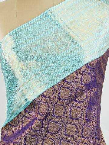 Kanchipuram Silk A regal burgundy Kanchipuram silk saree, woven from 100% pure silk with shimmering gold zari buttas adorning its body. The striking cyan border adds a vibrant contrast, making this drape perfect for grand occasions. Every weave echoes timeless tradition and handloom excellence. The rich hues speak of royal heritage, while the intricate zari work whispers stories of artisanal mastery. A timeless piece, crafted to grace your most cherished moments.          #ManoranjithamSilks #KanjivaramHand