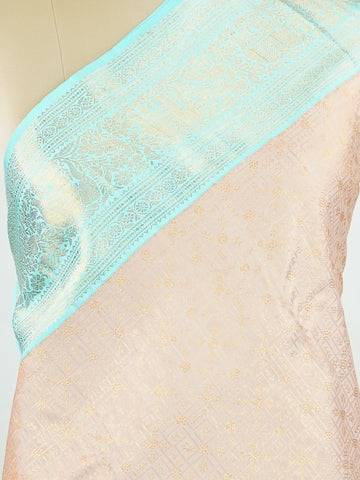 Kanchipuram Silk A delicate peach Kanchipuram silk saree woven with gold zari buttas, reflecting quiet sophistication. The cyan border adds a refreshing vibrance, creating a unique interplay of colours. Crafted from 100% pure silk, this saree is a testament to timeless handloom artistry. Perfect for bridal trousseaus and festive celebrations.          #ManoranjithamSilks #KanjivaramHandloom #PureSilkSaree #BridalElegance #TimelessTradition Surutia - Pure Kanjivaram Silk Saree | Zari Buttas - Manoranjitham W