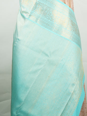 Kanchipuram Silk A delicate peach Kanchipuram silk saree woven with gold zari buttas, reflecting quiet sophistication. The cyan border adds a refreshing vibrance, creating a unique interplay of colours. Crafted from 100% pure silk, this saree is a testament to timeless handloom artistry. Perfect for bridal trousseaus and festive celebrations.          #ManoranjithamSilks #KanjivaramHandloom #PureSilkSaree #BridalElegance #TimelessTradition Surutia - Pure Kanjivaram Silk Saree | Zari Buttas - Manoranjitham W