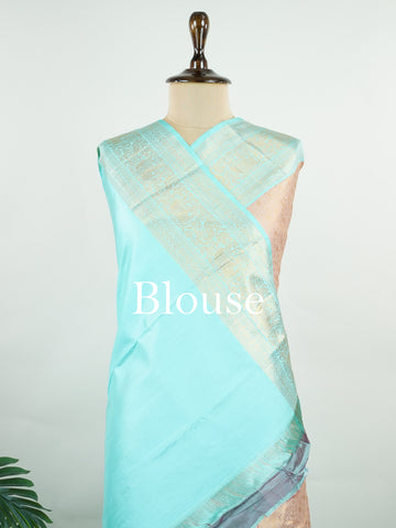 Kanchipuram Silk A delicate peach Kanchipuram silk saree woven with gold zari buttas, reflecting quiet sophistication. The cyan border adds a refreshing vibrance, creating a unique interplay of colours. Crafted from 100% pure silk, this saree is a testament to timeless handloom artistry. Perfect for bridal trousseaus and festive celebrations.          #ManoranjithamSilks #KanjivaramHandloom #PureSilkSaree #BridalElegance #TimelessTradition Surutia - Pure Kanjivaram Silk Saree | Zari Buttas - Manoranjitham W