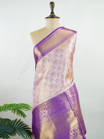 Kanchipuram Silk Soft peach silk meets purple borders, woven with gold and silver zari buttas that shimmer in every glance. This saree blends grace with tradition, perfect for festive moments. Crafted from 100% pure silk, it carries the artistry of timeless handlooms. A drape to cherish forever.                #ManoranjithamSilks #KanjivaramHandloom #PureSilkSaree #BridalElegance #TimelessTradition Sindhu - Peach Pure Kanjivaram Silk Saree | Zari Buttas - Manoranjitham Weaves - Handloom Store