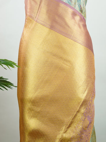 Kanchipuram Silk Earthy olive green silk paired with red borders, woven with gold and silver zari buttas that glimmer softly. This saree blends tradition with understated elegance. Made from 100% pure silk, it speaks of timeless beauty. A perfect drape for weddings and special occasions.            #ManoranjithamSilks #KanjivaramHandloom #PureSilkSaree #BridalElegance #TimelessTradition Gowrimanohari - Green Pure Kanjivaram Silk Saree | Zari Buttas - Manoranjitham Weaves - Handloom Store