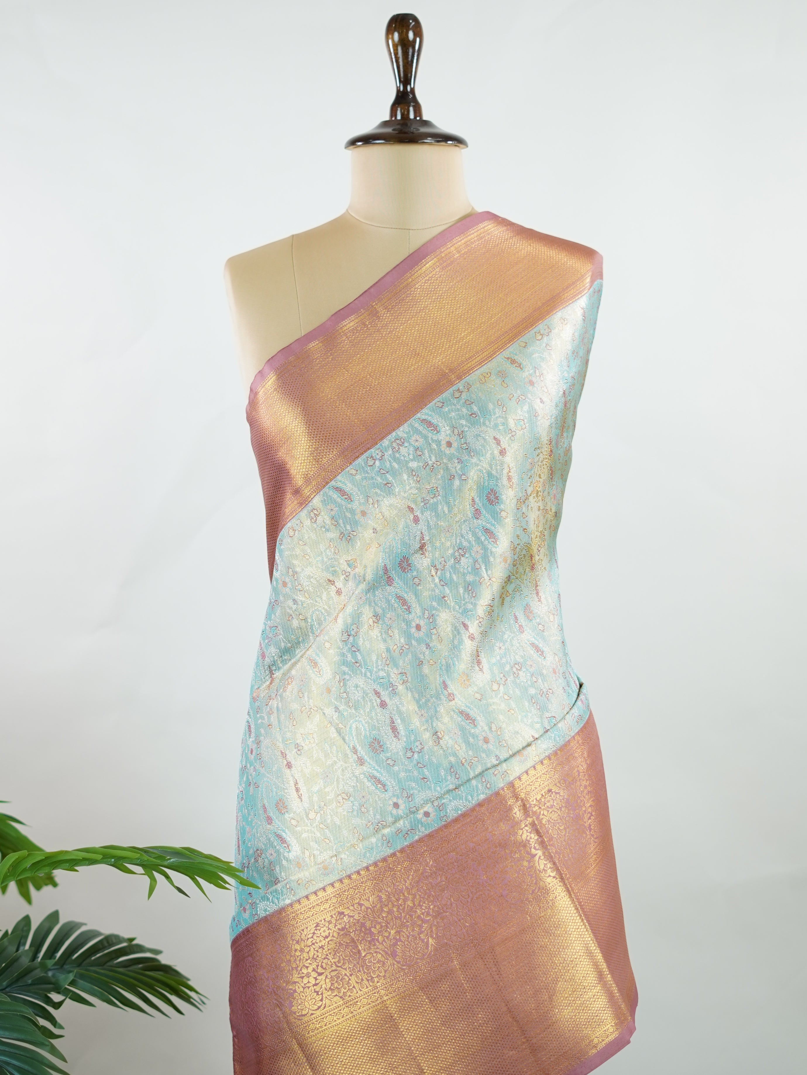 Kanchipuram Silk Earthy olive green silk paired with red borders, woven with gold and silver zari buttas that glimmer softly. This saree blends tradition with understated elegance. Made from 100% pure silk, it speaks of timeless beauty. A perfect drape for weddings and special occasions.            #ManoranjithamSilks #KanjivaramHandloom #PureSilkSaree #BridalElegance #TimelessTradition Gowrimanohari - Green Pure Kanjivaram Silk Saree | Zari Buttas - Manoranjitham Weaves - Handloom Store