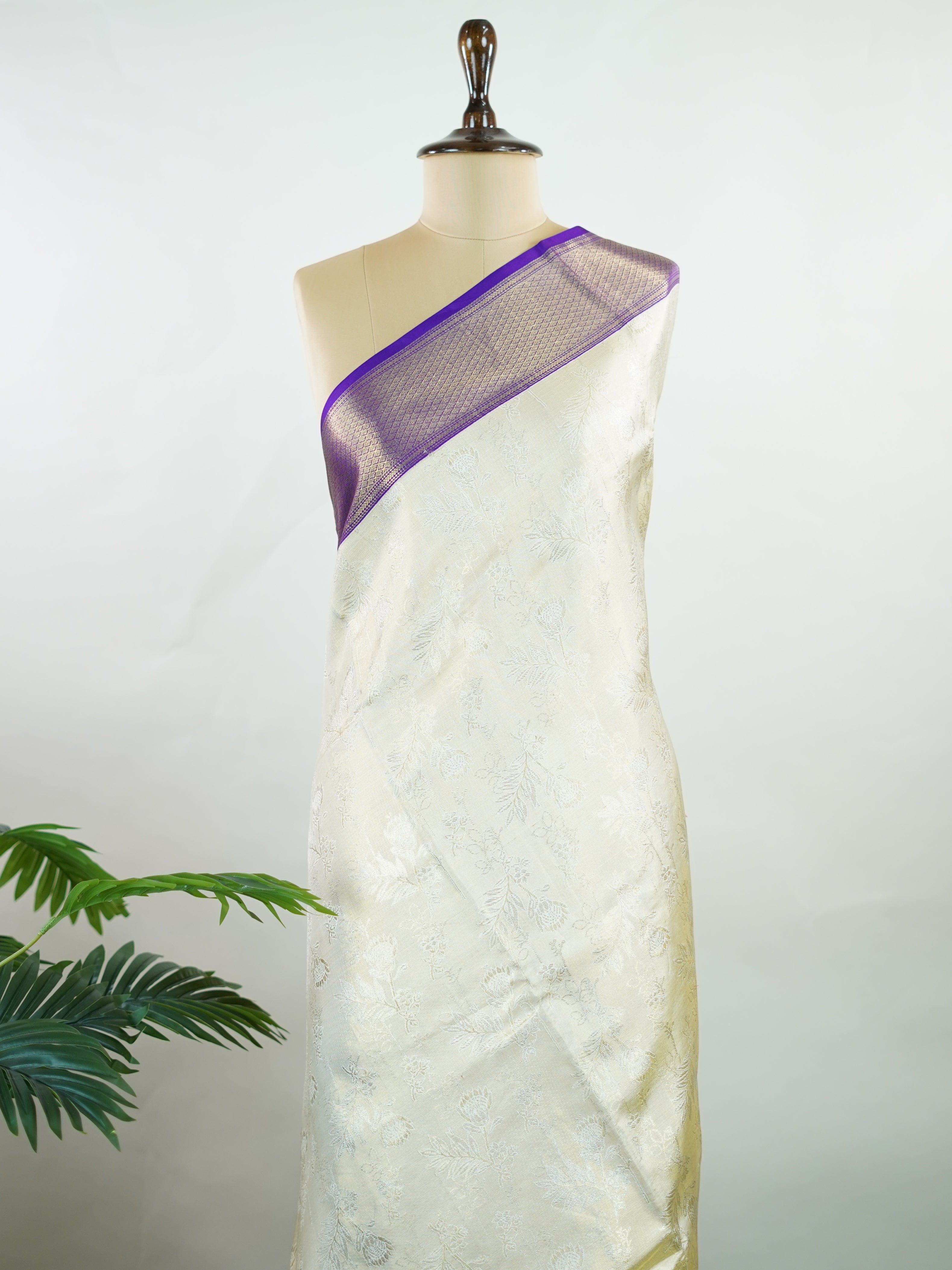 Kanchipuram Silk A classic cream silk saree with purple borders, adorned with delicate zari buttis scattered across the weave. The rich contrast blends tradition with grace. Woven in Kanchipuram from 100% pure silk, it's perfect for weddings and festive occasions. A timeless drape for treasured moments.                     #ManoranjithamSilks #KanjivaramHandloom #PureSilkSaree #BridalElegance #TimelessTradition Vagadeeshwari - Cream Pure Kanjivaram Silk Saree | Zari Buttas - Manoranjitham Weaves - Handloom 
