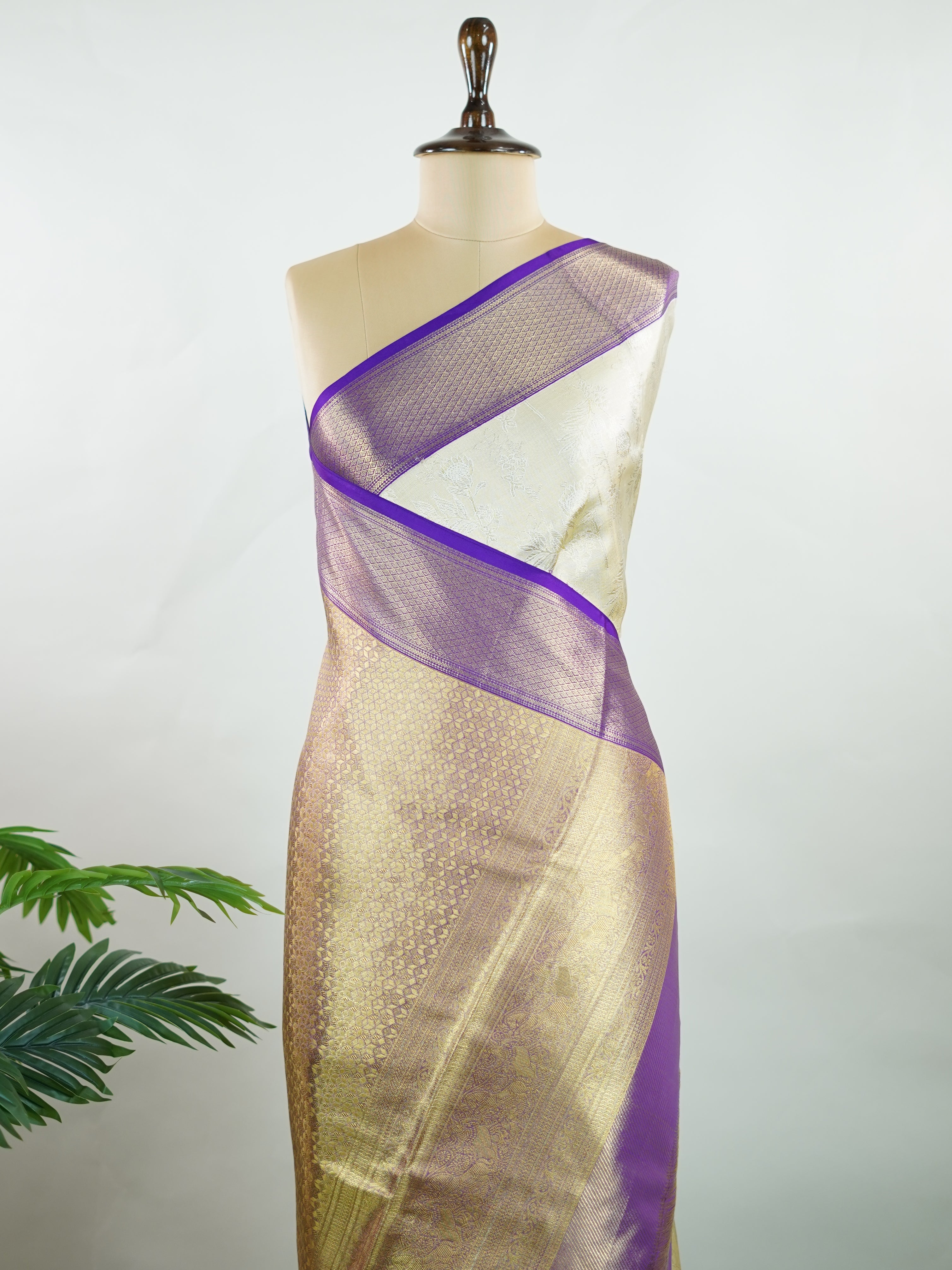 Kanchipuram Silk A classic cream silk saree with purple borders, adorned with delicate zari buttis scattered across the weave. The rich contrast blends tradition with grace. Woven in Kanchipuram from 100% pure silk, it's perfect for weddings and festive occasions. A timeless drape for treasured moments.                     #ManoranjithamSilks #KanjivaramHandloom #PureSilkSaree #BridalElegance #TimelessTradition Vagadeeshwari - Cream Pure Kanjivaram Silk Saree | Zari Buttas - Manoranjitham Weaves - Handloom 