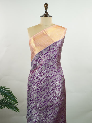 Kanchipuram Silk A rich dark magenta silk saree with peach borders, adorned with delicate silver zari buttas that glisten across the weave. The vibrant contrast exudes grace and tradition. Handwoven in Kanchipuram with 100% pure silk, it's perfect for weddings and festive celebrations. A timeless drape for treasured moments.                  #ManoranjithamSilks #KanjivaramHandloom #PureSilkSaree #BridalElegance #TimelessTradition Kuntalavarali - Magenta Pure Kanjivaram Silk Saree | Zari Buttas - Manoranjith