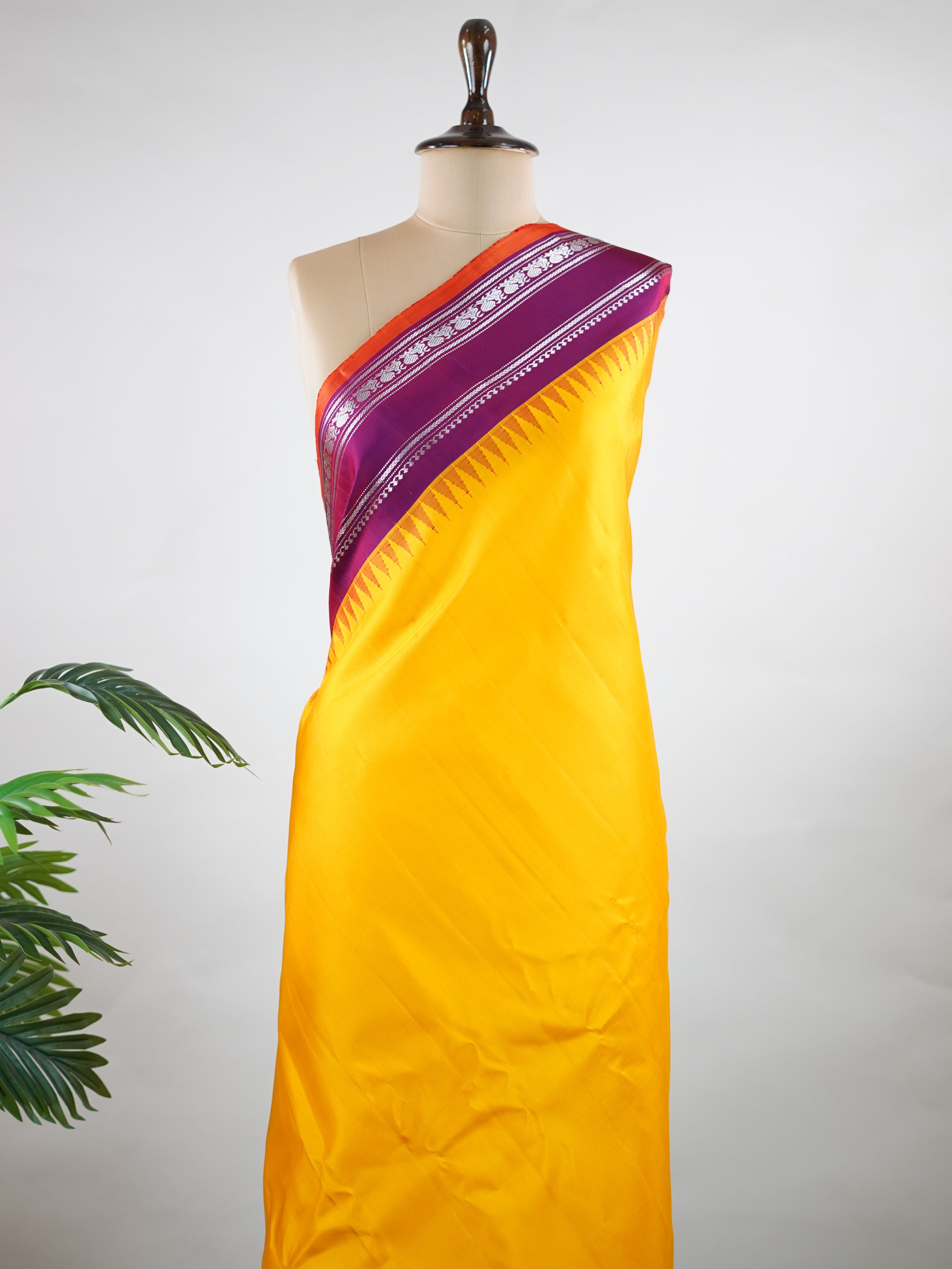 Gadwal Silk This vibrant Gadwal saree features a yellow body paired with a magenta pink border, crafted from 100% pure silk.br
The body is adorned with delicate resham checks, adding texture and understated elegance.br
Finished with a graceful gap border, it beautifully showcases the timeless handloom artistry of Gadwal weaving. Shankari - Yellow Handloom Gadwal Silk Saree | Pure Silk | Zari Border - Manoranjitham Weaves - Handloom Store