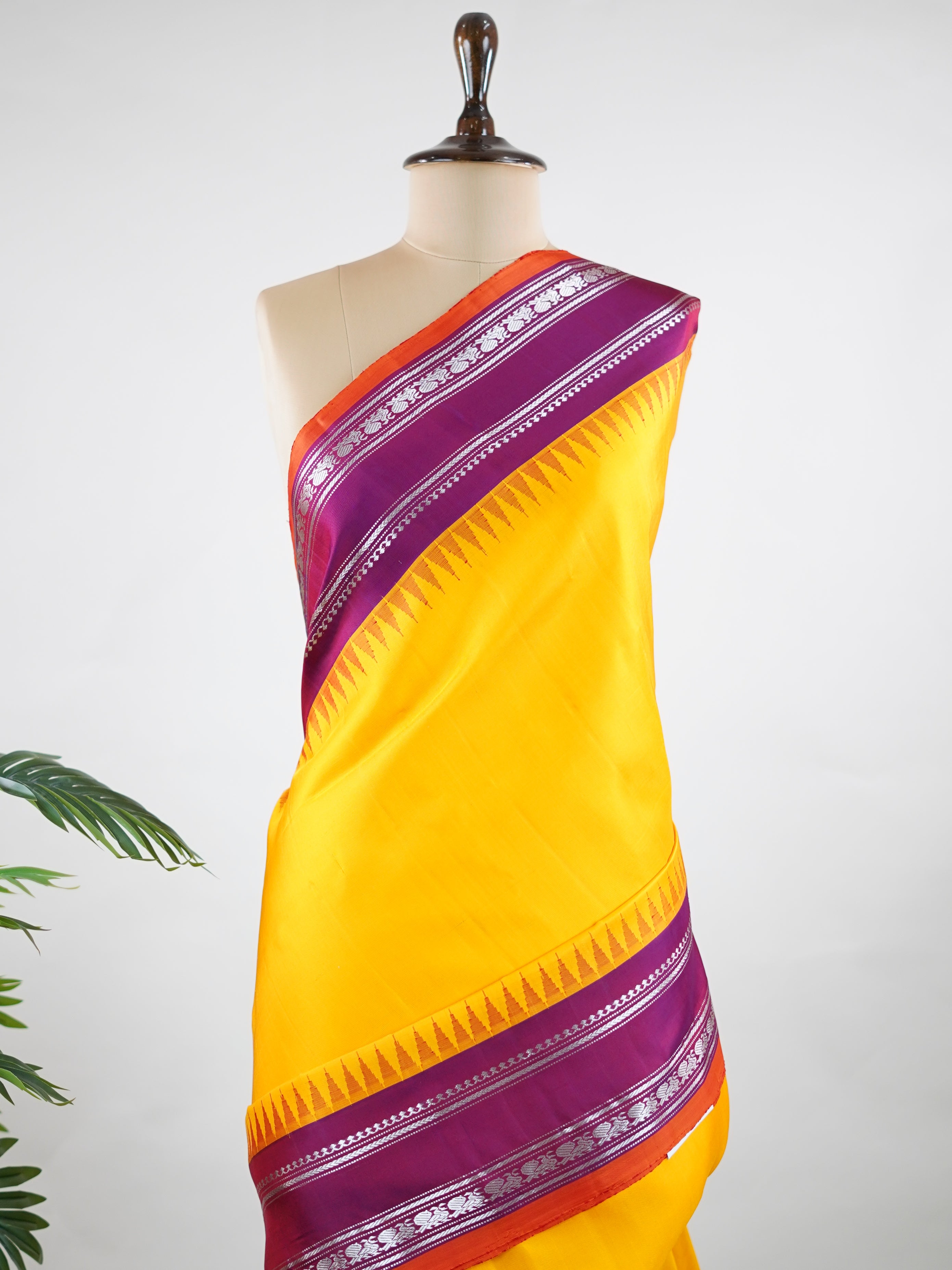 Gadwal Silk This vibrant Gadwal saree features a yellow body paired with a magenta pink border, crafted from 100% pure silk.br
The body is adorned with delicate resham checks, adding texture and understated elegance.br
Finished with a graceful gap border, it beautifully showcases the timeless handloom artistry of Gadwal weaving. Shankari - Yellow Handloom Gadwal Silk Saree | Pure Silk | Zari Border - Manoranjitham Weaves - Handloom Store