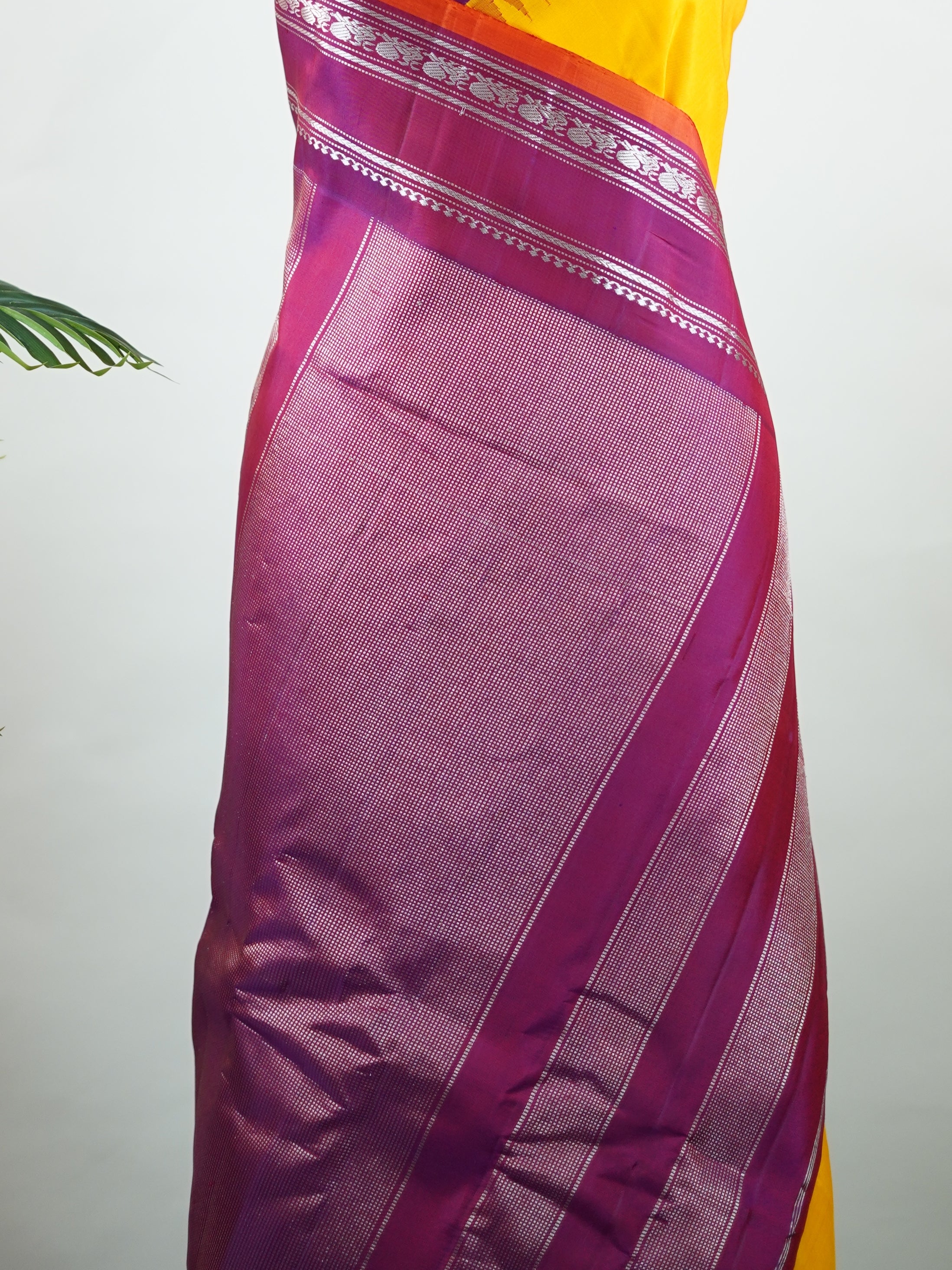 Gadwal Silk This vibrant Gadwal saree features a yellow body paired with a magenta pink border, crafted from 100% pure silk.br
The body is adorned with delicate resham checks, adding texture and understated elegance.br
Finished with a graceful gap border, it beautifully showcases the timeless handloom artistry of Gadwal weaving. Shankari - Yellow Handloom Gadwal Silk Saree | Pure Silk | Zari Border - Manoranjitham Weaves - Handloom Store