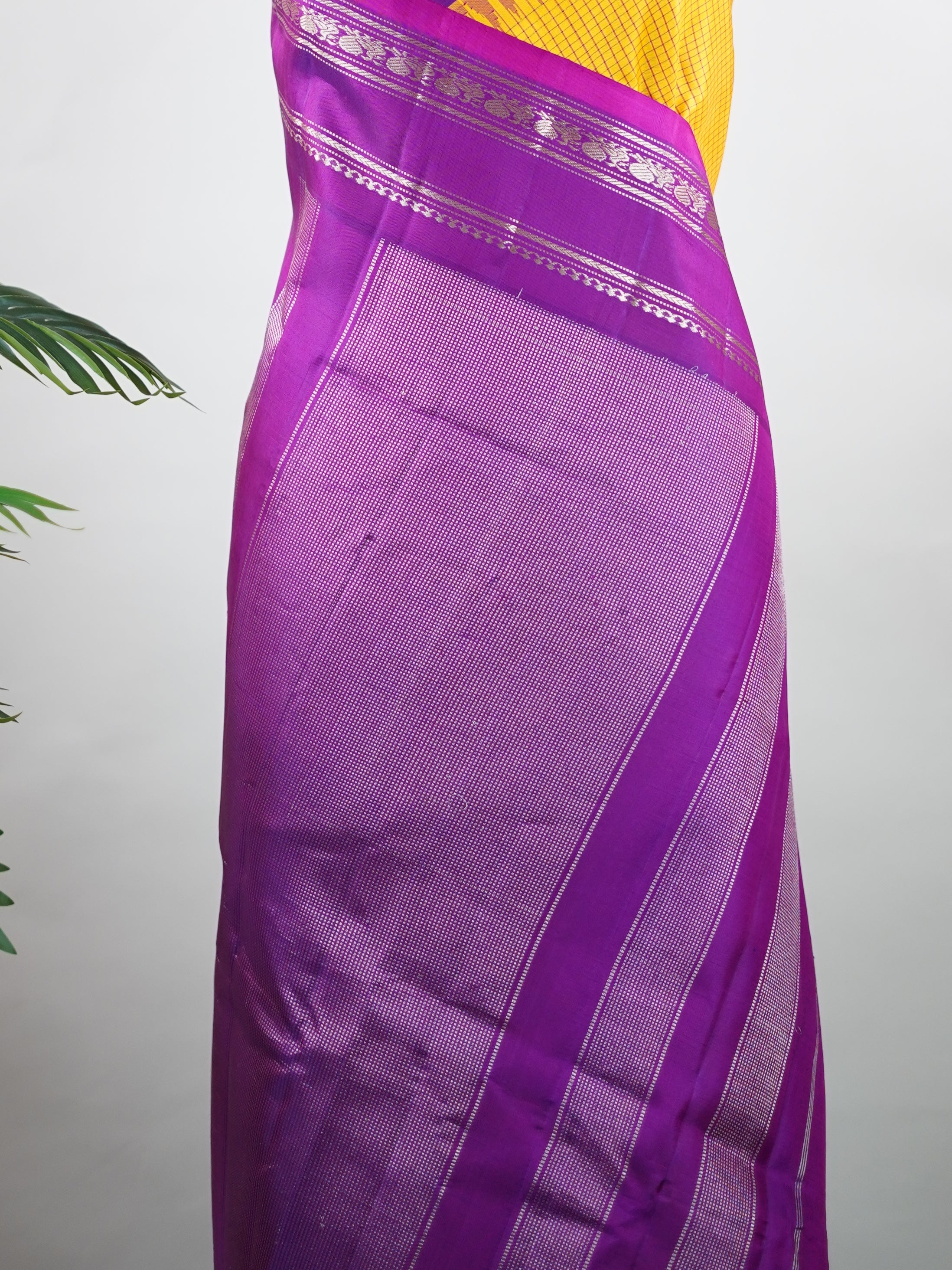 Gadwal Silk This elegant Gadwal saree features a yellow body paired with a magenta pink border, crafted from 100% pure silk.br
The plain body offers a clean, sophisticated look, perfect for any occasion.br
Finished with a graceful gap border, it highlights the timeless handloom craftsmanship of Gadwal weaving. Sreekari - Yellow Handloom Gadwal Silk Saree | Pure Silk | Zari Border - Manoranjitham Weaves - Handloom Store