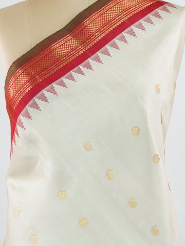 Gadwal Silk This elegant Gadwal saree features a beige body paired with a red border, crafted from 100% pure silk.br
The body is adorned with delicate gold mango and rudraksha buttis, adding a touch of traditional charm.br
Finished with a subtle small border, it showcases the exquisite handloom artistry of Gadwal weaving. Mangala - Beige Handloom Gadwal Silk Saree | Pure Silk | Zari Border - Manoranjitham Weaves - Handloom Store