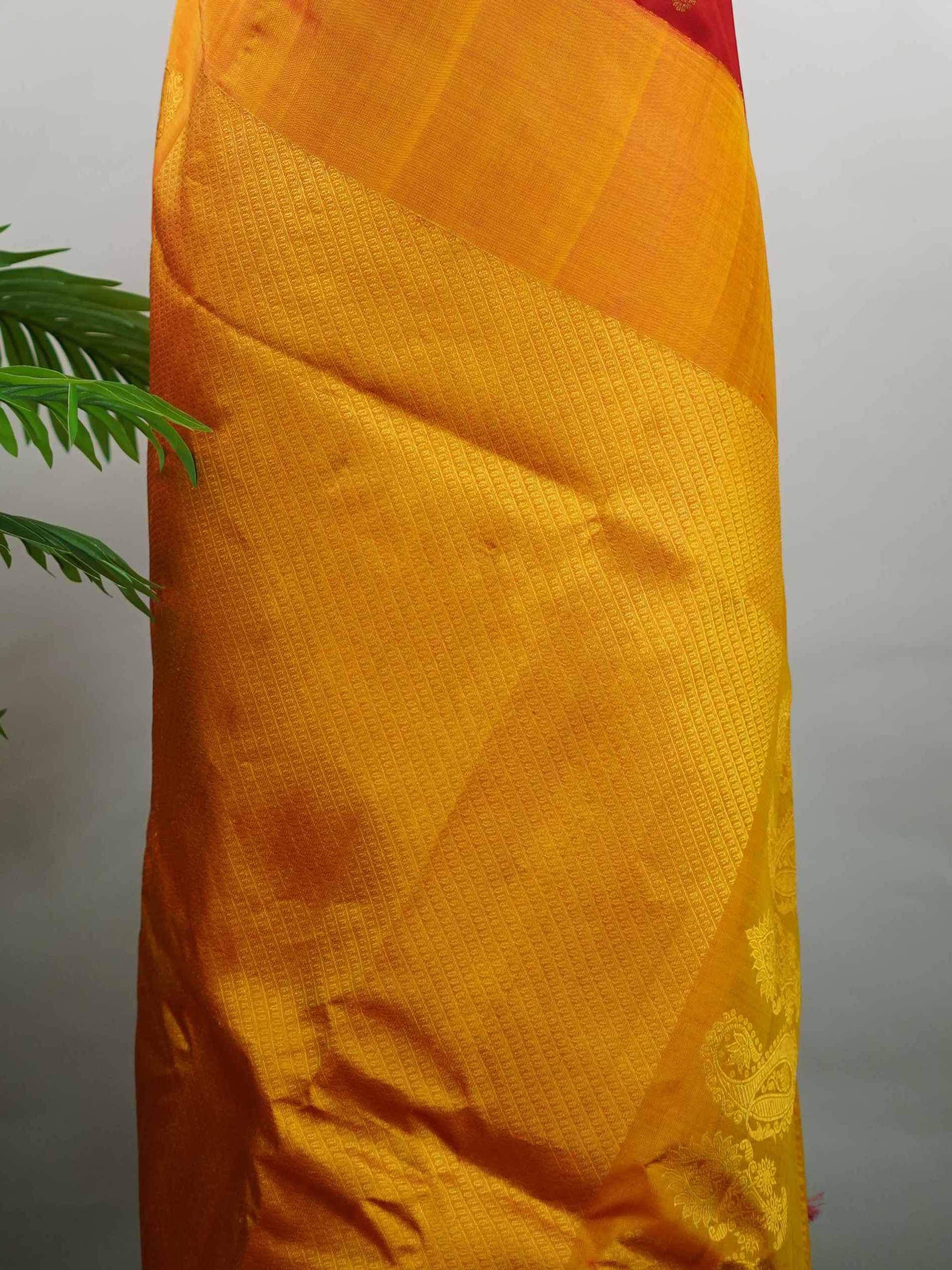 Gadwal Silk This vibrant Gadwal saree features a red body paired with a mustard border, crafted from 100% pure silk.br
The body is adorned with delicate thread buttis, while the border showcases traditional temple kota kommas for a classic touch.br
Completed with a contrasting blouse, it highlights exquisite handloom craftsmanship and timeless elegance. Ekanta - Red Handloom Gadwal Silk Saree | Pure Silk | Zari Border - Manoranjitham Weaves - Handloom Store