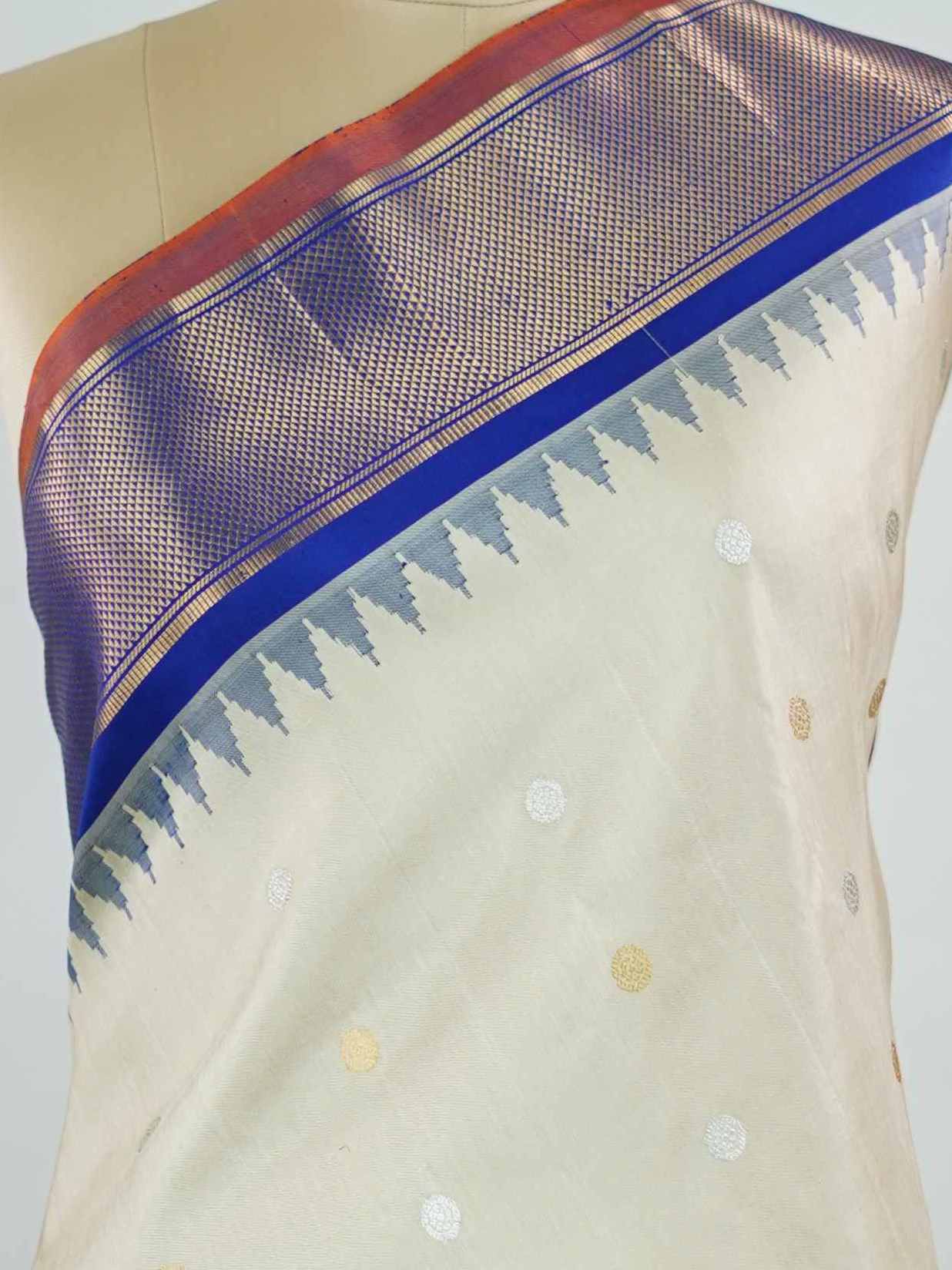 Gadwal Silk Elevate your ethnic elegance with this Gadwal saree in a graceful beige shade, paired with a royal blue blouse. The saree is beautifully adorned with gold and silver buttas that add a subtle festive shimmer. Its traditional weave ensures a rich drape that blends sophistication with cultural charm. Perfect for weddings, festive occasions, and celebrations that call for timeless beauty. Shivaatmika - Handloom Gadwal Silk Saree | Pure Silk | Zari Border - Manoranjitham Weaves - Handloom Store