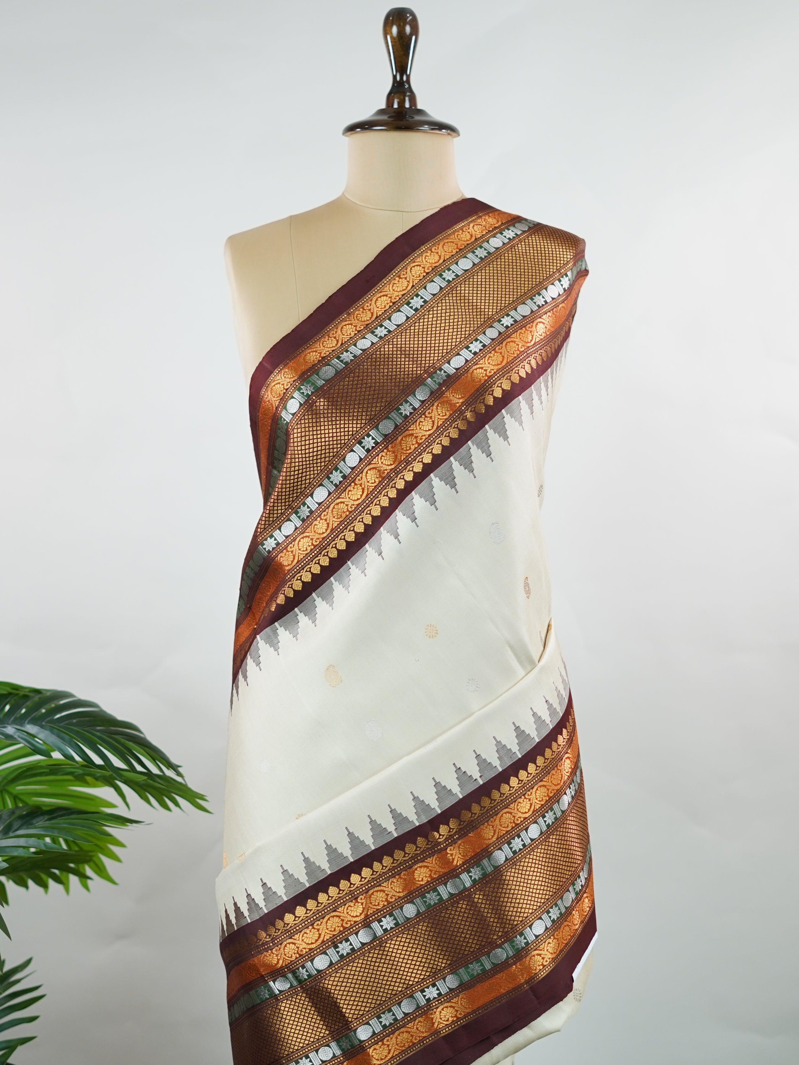 Gadwal Silk This elegant Gadwal saree features a beige body paired with a rich brown border, crafted from 100% pure silk.br
The body is adorned with subtle zari buttis, adding delicate shimmer and charm.br
Finished with a bold, wide border, it showcases the classic handloom artistry of Gadwal weaving. Parvathipriya - Gadwal  saree - Manoranjitham Weaves - Handloom Store