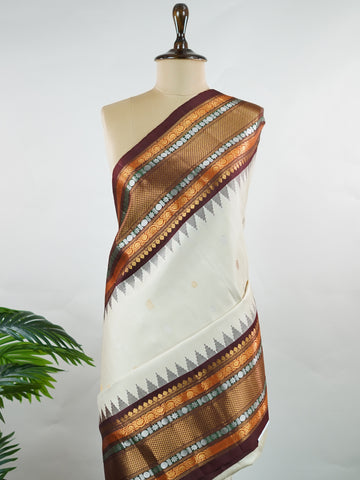 Gadwal Silk This elegant Gadwal saree features a beige body paired with a rich brown border, crafted from 100% pure silk.br
The body is adorned with subtle zari buttis, adding delicate shimmer and charm.br
Finished with a bold, wide border, it showcases the classic handloom artistry of Gadwal weaving. Parvathipriya - Gadwal  saree - Manoranjitham Weaves - Handloom Store