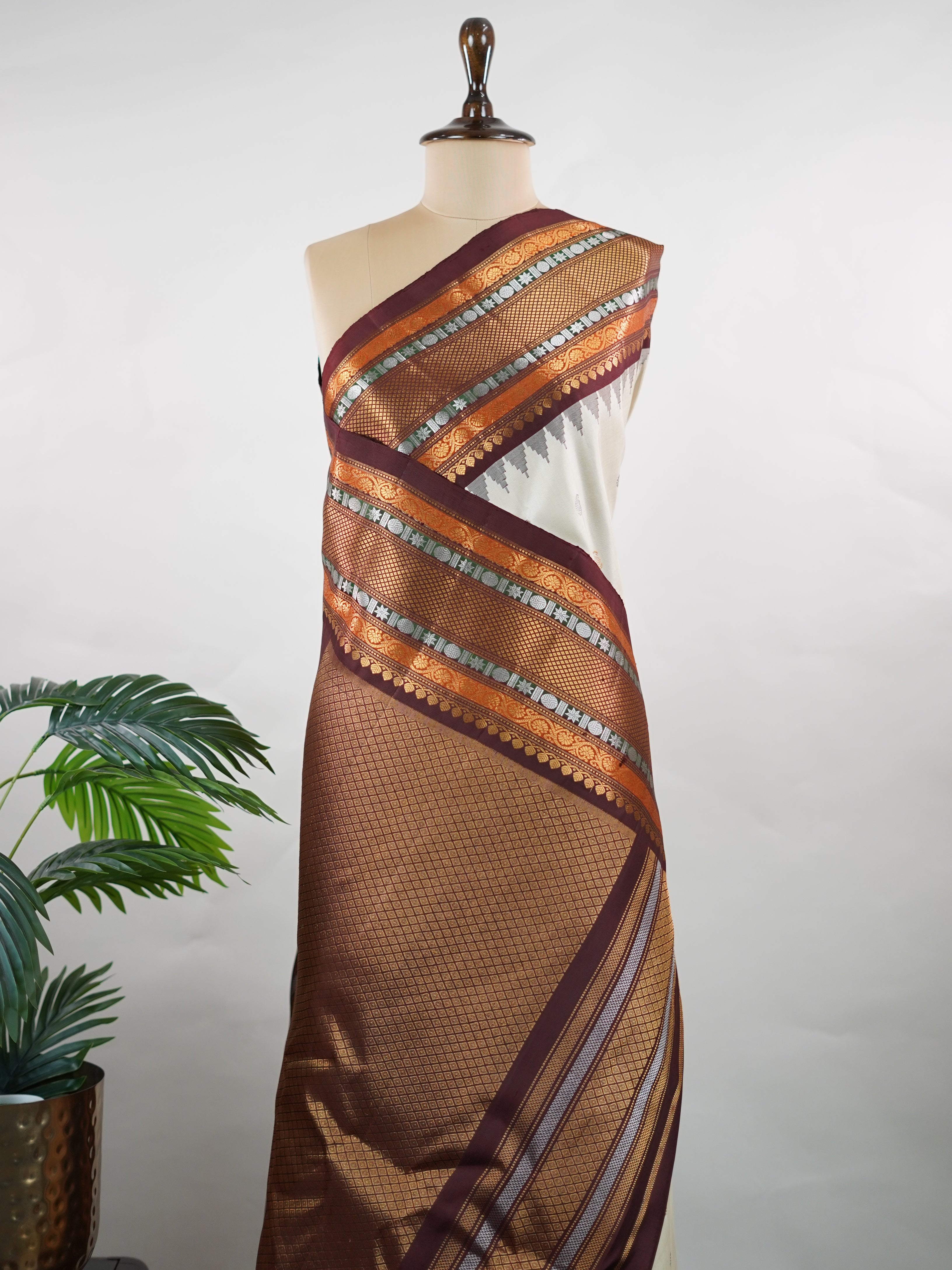 Gadwal Silk This elegant Gadwal saree features a beige body paired with a rich brown border, crafted from 100% pure silk.br
The body is adorned with subtle zari buttis, adding delicate shimmer and charm.br
Finished with a bold, wide border, it showcases the classic handloom artistry of Gadwal weaving. Parvathipriya - Gadwal  saree - Manoranjitham Weaves - Handloom Store