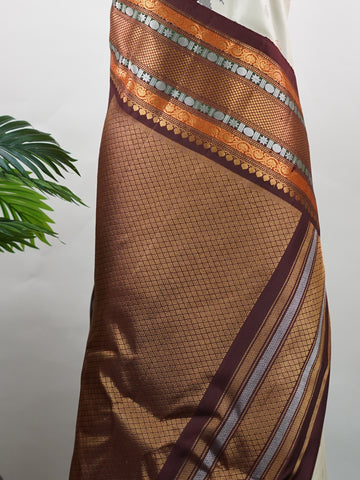 Gadwal Silk This elegant Gadwal saree features a beige body paired with a rich brown border, crafted from 100% pure silk.br
The body is adorned with subtle zari buttis, adding delicate shimmer and charm.br
Finished with a bold, wide border, it showcases the classic handloom artistry of Gadwal weaving. Parvathipriya - Gadwal  saree - Manoranjitham Weaves - Handloom Store