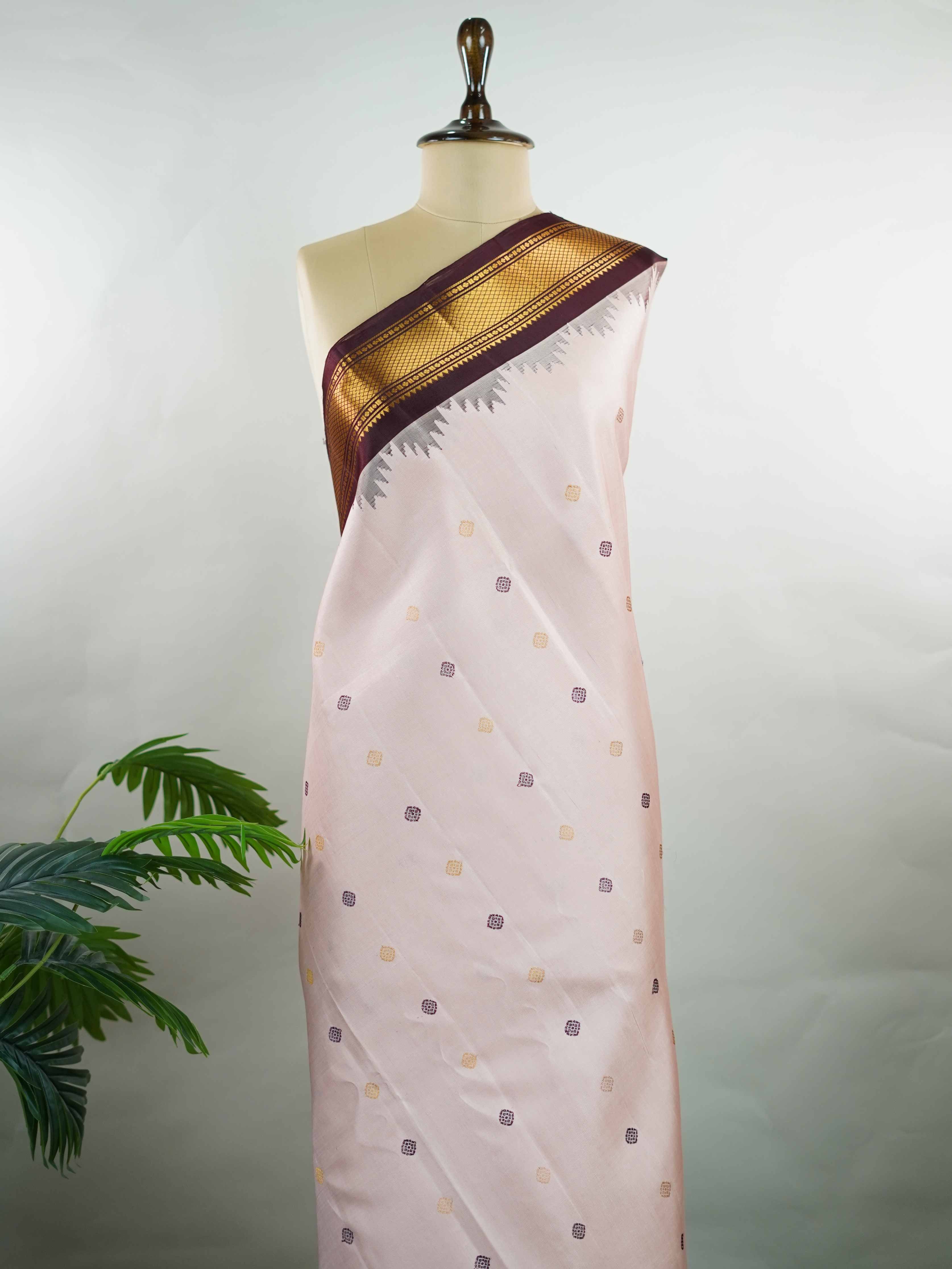 Gadwal Silk Make a graceful statement with this Gadwal saree in a rich peach shade, paired with a deep brown blouse. The design is enhanced with elegant gold and silk buttas, reflecting traditional craftsmanship and subtle luxury. Its classic weave ensures a refined drape that beautifully blends comfort with sophistication. Perfect for festive occasions, cultural events, and celebrations that call for timeless ethnic elegance. Indumati - Handloom Gadwal Silk Saree | Pure Silk | Zari Border - Manoranjitham W