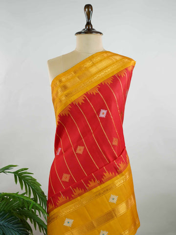 Gadwal Silk Make a striking statement with this elegant Gadwal saree in a vibrant red shade, paired beautifully with a contrasting yellow blouse. The design is adorned with intricate silver and gold kolam buttas, reflecting traditional artistry and cultural richness. The classic weave enhances its graceful drape, giving it a timeless and festive appeal. Perfect for weddings, festive celebrations, and auspicious occasions that call for a regal traditional look. Vinata - Handloom Gadwal Silk Saree | Pure Silk