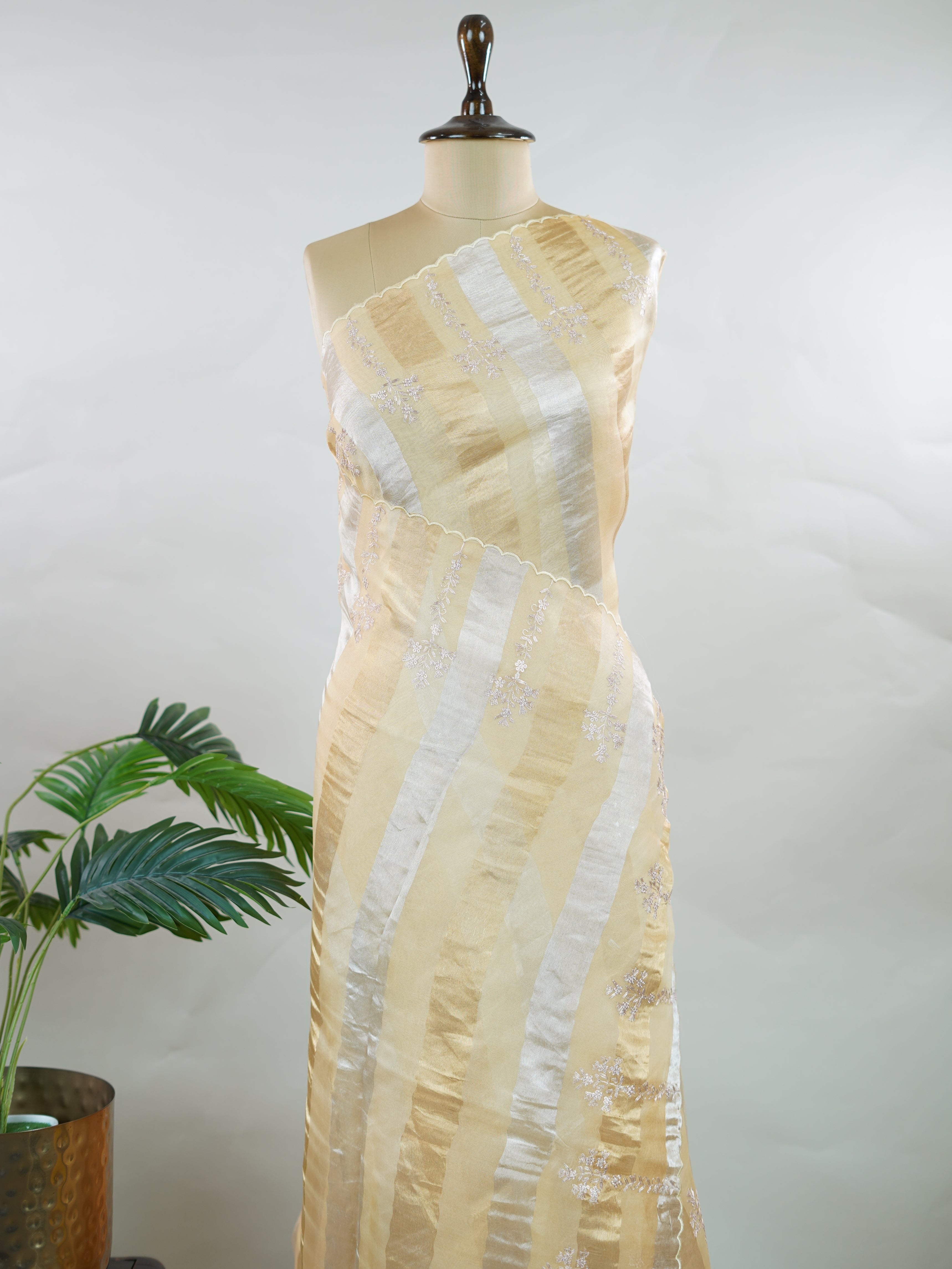 Organza Elegant organza saree in gold and cream hues featuring exquisite Aari Peeta work on the pallu. The sheer, lightweight fabric drapes gracefully, creating a regal and refined silhouette.br data-start=186 data-end=189Intricate handcrafted embroidery adds richness, texture, and timeless traditional charm.br data-start=277 data-end=280Perfect for weddings, festive celebrations, and special occasions with classic elegance. Dhanya - Organza Saree | Embroidered - Manoranjitham Weaves - Handloom Store