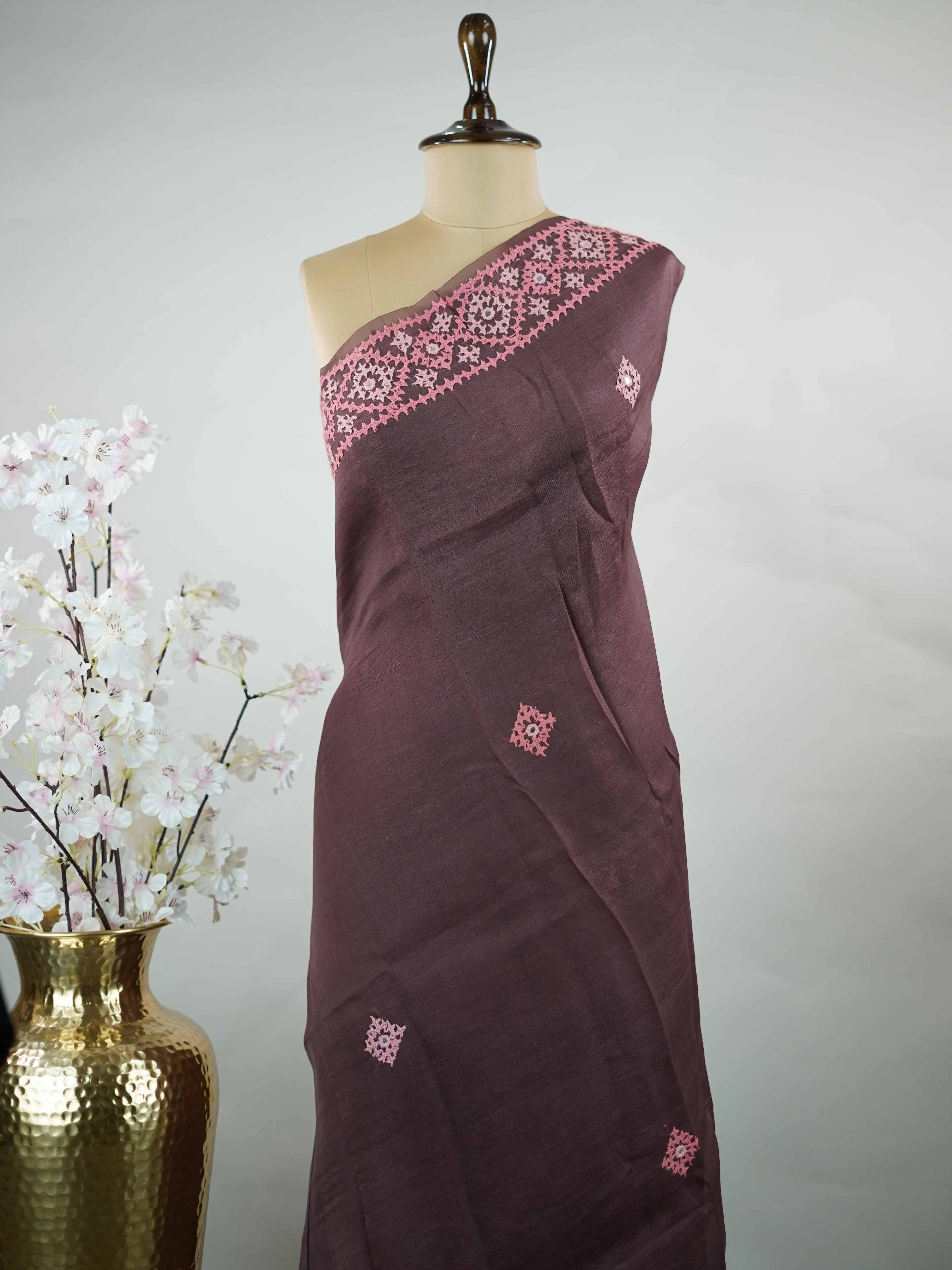 Katan A warm brown Kora saree highlighted with soft pink accents, creating a graceful contrast.br
Enhanced with vibrant Kutch embroidery, it showcases rich artisanal detail with a refined, contemporary appeal. Kadhambari - Warm Brown Kora Silk Saree | Kutch Work - Manoranjitham Weaves - Handloom Store