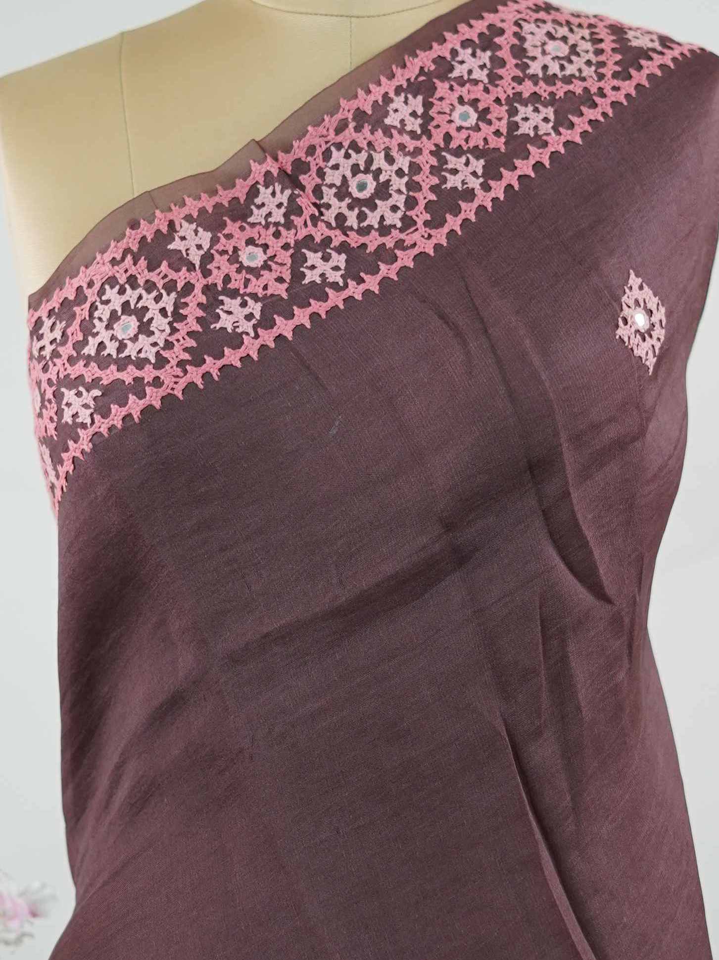 Katan A warm brown Kora saree highlighted with soft pink accents, creating a graceful contrast.br
Enhanced with vibrant Kutch embroidery, it showcases rich artisanal detail with a refined, contemporary appeal. Kadhambari - Warm Brown Kora Silk Saree | Kutch Work - Manoranjitham Weaves - Handloom Store