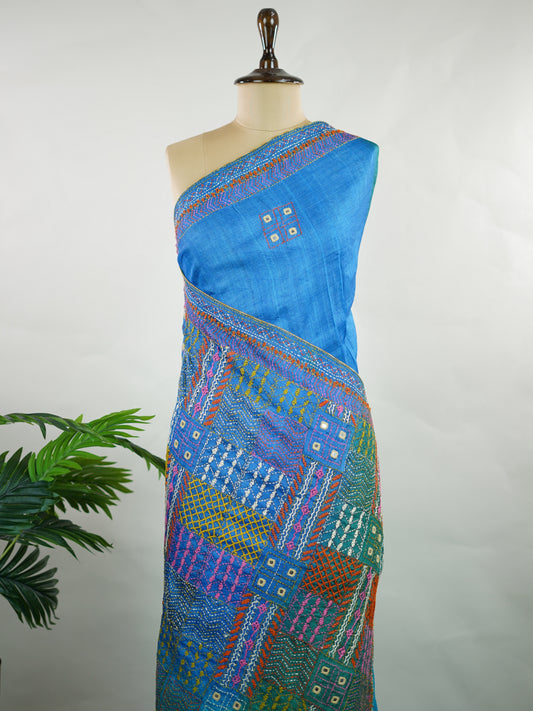 Tussar Rich Kutch embroidery beautifully highlights the heavy pallu with vibrant threads, intricate motifs, and signature mirror work, adding grandeur to the natural elegance of Tussar silk.

Balanced with a simple, subtly finished blouse, this saree creates the perfect blend of bold craftsmanship and graceful sophistication—ideal for festive and special occasions. Kameshi - Manoranjitham Weaves - Handloom Store