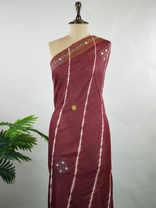 Tussar A stunning fusion of vibrant Leheriya patterns and intricate Kutch embroidery, this Tussar silk saree is a true celebration of color and craft. The playful wave-like stripes beautifully contrast with bold mirror work and detailed thread motifs.ication—ideal for festive and special occasions. Veena - Manoranjitham Weaves - Handloom Store