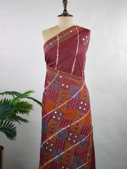 Tussar A stunning fusion of vibrant Leheriya patterns and intricate Kutch embroidery, this Tussar silk saree is a true celebration of color and craft. The playful wave-like stripes beautifully contrast with bold mirror work and detailed thread motifs.ication—ideal for festive and special occasions. Veena - Manoranjitham Weaves - Handloom Store