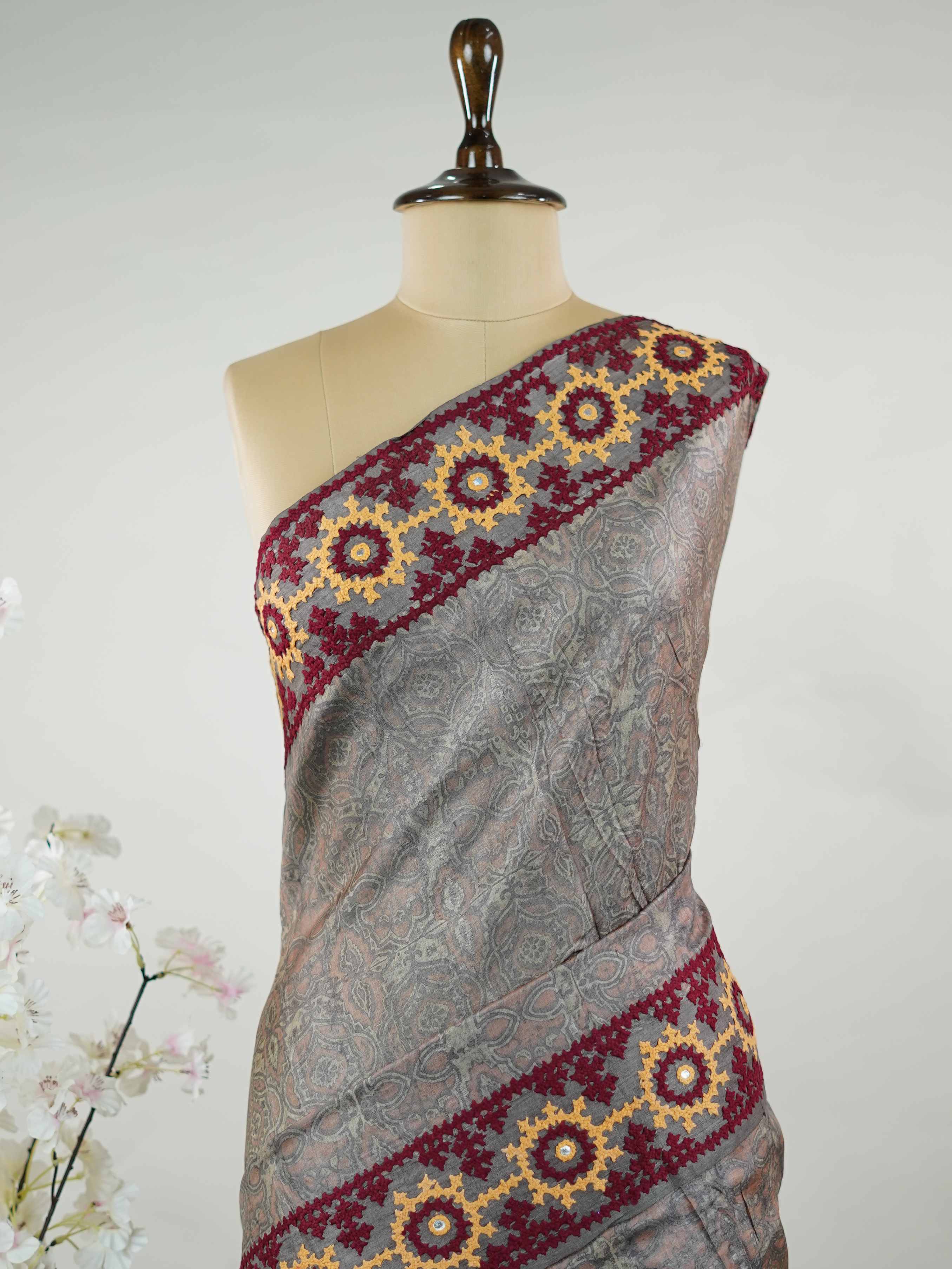 Tussar A refined Tussar saree in a rich grey base, highlighted with striking red accents for a bold contrast.br
Adorned with intricate Kutch embroidery, it celebrates vibrant craftsmanship with a timeless appeal. Priya - Grey Tussar Silk Saree | Kutch Work - Manoranjitham Weaves - Handloom Store