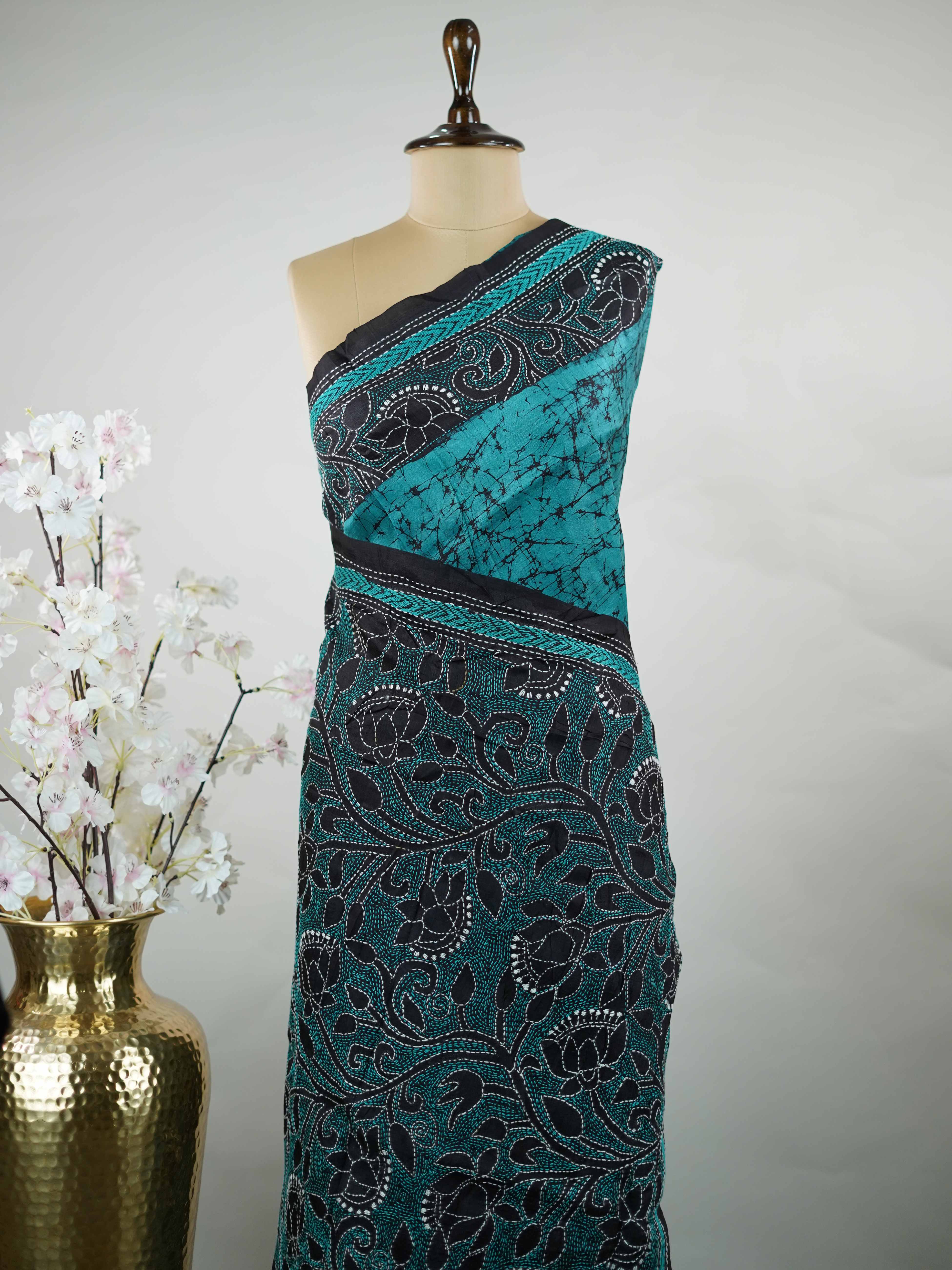 Tussar A striking blue soft silk saree paired with deep black accents, creating a bold and elegant contrast.br
Detailed with fine Kantha stitching and modern digital prints, it beautifully blends heritage craft with contemporary style. Varuni - Tussar Silk Saree | Kantha Embroidery - Manoranjitham Weaves - Handloom Store