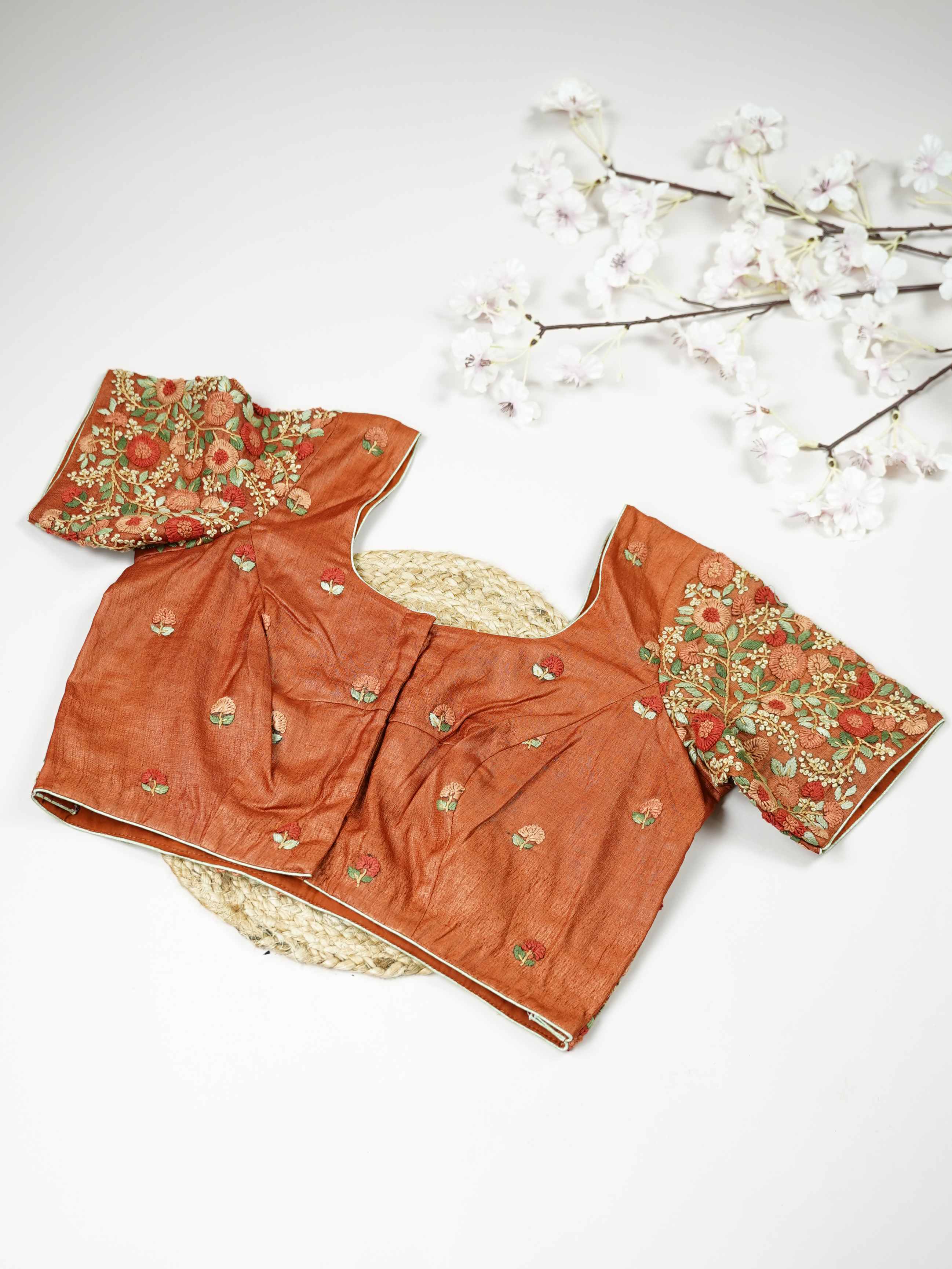Tussar This elegant orange Tussar blouse features finely stitched hand embroidery with delicate floral designs. The intricate flower patterns add a rich and graceful handcrafted charm.br data-start=179 data-end=182The vibrant orange shade enhances the embroidery, giving it a bright and festive appeal.br data-start=270 data-end=273Perfect for ethnic wear, it creates a stylish and beautifully detailed traditional look. Sutrika - Tussar Silk Saree | Hand Embroidered - Manoranjitham Weaves - Handloom Store