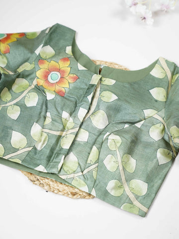 Tussar This elegant leaf green Tussar blouse features finely stitched hand-painted Pen Kalamkari floral designs. The intricate artwork reflects traditional craftsmanship with beautiful artistic detailing. The fresh leaf green shade enhances the painted flowers, giving it a natural and graceful appeal. Perfect for ethnic wear, it creates a stylish and uniquely handcrafted traditional look. Kamini - Tussar Silk Saree | Hand Embroidered - Manoranjitham Weaves - Handloom Store
